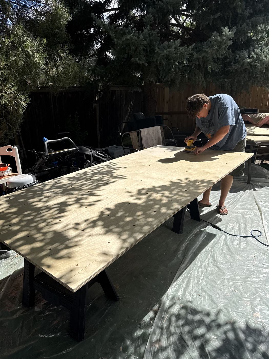 Someone drilling a climbing wall panel outdoors